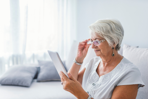 Elderly woman with Diabetic Retinopathy reading with eyeglasses